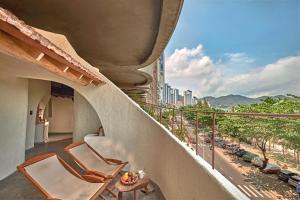 a balcony with two chairs and a table and a city at Ibala Hotel & Spa in Nha Trang