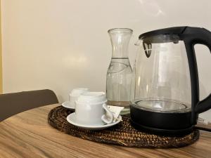 a black coffee maker and cups on a table at Yes Hotel San Ildefonso Bulacan in Buliran +78 photos