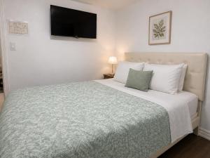 ein Schlafzimmer mit einem großen Bett und einem Fernseher an der Wand in der Unterkunft TononHouse in Toronto