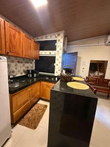 a kitchen with wooden cabinets and a black counter top at Condomínio Feitosa Barros I in Maceió