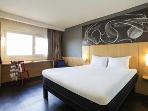 a bed in a room with a large white bed at ibis Bordeaux Lac in Bordeaux +149 photos