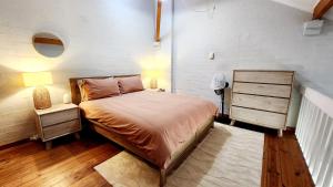 a bedroom with a bed and a white brick wall at Poolside Retreat 250m From Beach Resort Facilities in Mandurah