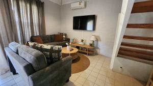 a living room with two couches and a tv at Poolside Retreat 250m From Beach Resort Facilities in Mandurah