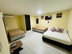 a hotel room with two beds and a tv at Posada Francelly in San Andrés