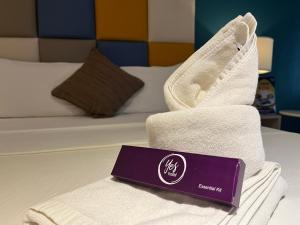 a pile of towels sitting on top of a bed at Yes Hotel San Ildefonso Bulacan in Buliran