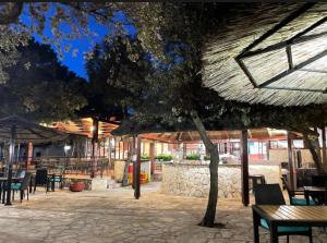 a patio with tables and chairs and a tree at Holiday Homes Lavanda - Biograd na Moru in Biograd na Moru