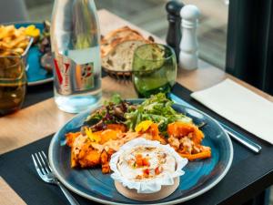 a blue plate of food on a table at Novotel Caen Côte de Nacre in Caen