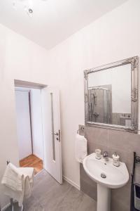 シビウにあるCentral Apartment Sibiuの白いバスルーム(シンク、鏡付)