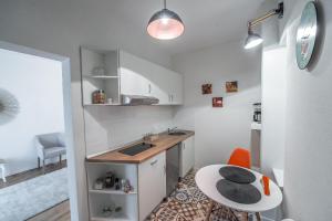 Central Studio Sibiu في سيبيو: مطبخ صغير مع حوض وطاولة