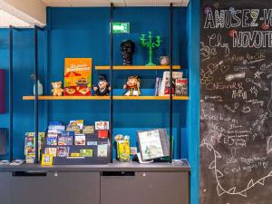 a classroom with a blue wall with a chalkboard at Novotel Dijon Sud in Dijon