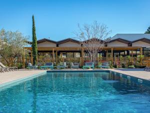 a swimming pool in front of a house at Novotel Perpignan Nord Rivesaltes in Rivesaltes