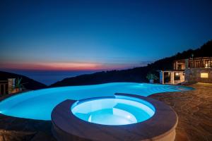 ein großer Swimmingpool in einem Garten bei Nacht in der Unterkunft Villa Amara Private Estate in Anafonítria