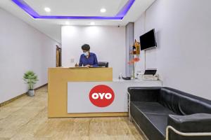 a person wearing a mask at a counter in an office at Hotel O Fox Guest House in Greater Noida
