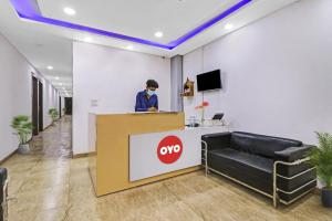 a person wearing a mask at a counter in an office at Hotel O Fox Guest House in Greater Noida