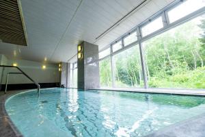 a large indoor swimming pool with a large window at Okushiga Kogen Hotel in Yamanouchi +58 photos