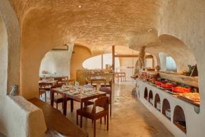 a dining room with tables and chairs and a kitchen at Ibala Hotel & Spa in Nha Trang