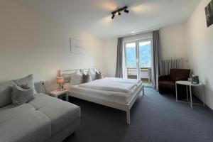 a bedroom with a bed and a couch and a window at Frühstückspension Irschen in Irschen