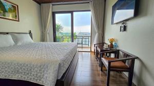 a bedroom with a bed and a view of a balcony at Tam Cốc Hà Anh Hotel in Văn Lâm +52 photos