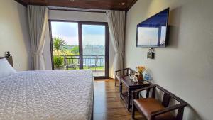 a bedroom with a bed and a large window at Tam Cốc Hà Anh Hotel in Văn Lâm