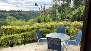 a table and chairs on a patio with a view at Riverwalk cabañas junto al rio in Calarcá