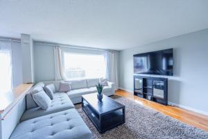 a living room with a couch and a tv at Cozy Prairie Mansion in Winnipeg