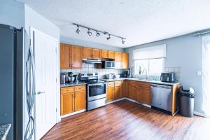 a kitchen with wooden cabinets and wooden floors at Cozy Prairie Mansion in Winnipeg