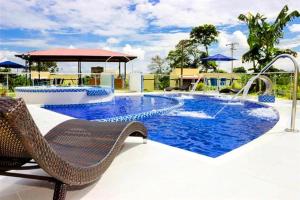 a swimming pool with a bench and a chair next to it at Riverwalk cabañas junto al rio in Calarcá