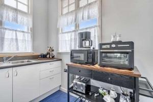 a kitchen with a counter with a microwave and appliances at Ruawai Post Office Accommodation in Ruawai