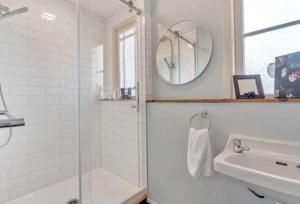 a bathroom with a shower and a sink and a mirror at Ruawai Post Office Accommodation in Ruawai