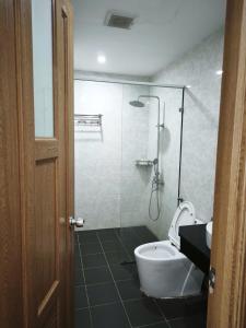 a bathroom with a toilet and a glass shower at Kakashi Hotel Phú Quốc in Phú Quốc