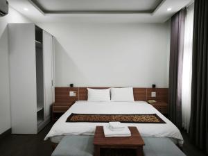a bedroom with a large bed and a table at Kakashi Hotel Phú Quốc in Phú Quốc
