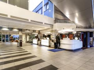 a man standing in the lobby of a building at Novotel Warszawa Airport in Warsaw