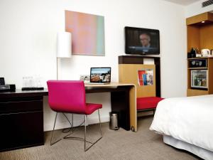 a hotel room with a desk with a computer and a bed at Novotel Warszawa Airport in Warsaw