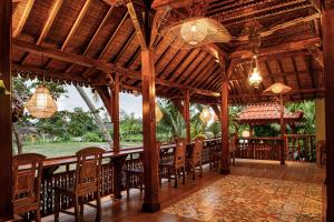 a dining room with a long table and chairs at Juwel Villa Ubud in Ubud