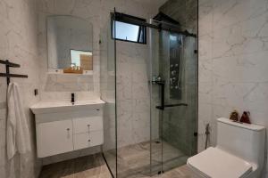 a bathroom with a shower and a sink and a toilet at ArtiZen Hideout near Hin Kong Beach in Hinkong +2 photos