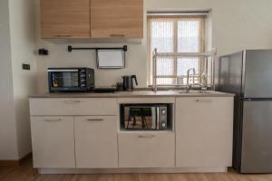 a kitchen with a microwave and a refrigerator at ArtiZen Hideout near Hin Kong Beach in Hinkong