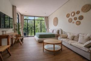 a living room with a couch and a table at ArtiZen Hideout near Hin Kong Beach in Hinkong