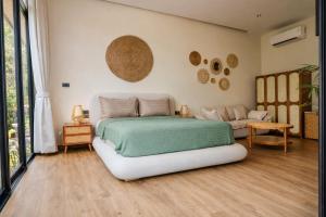 a bedroom with a large bed and a couch at ArtiZen Hideout near Hin Kong Beach in Hinkong