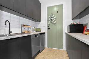 a kitchen with a sink and a green door at Dulwich Studio in Rose Park +8 photos