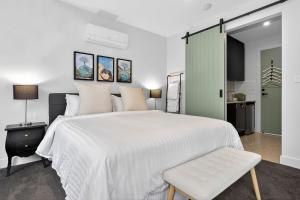 a bedroom with a large white bed and a chair at Dulwich Studio in Rose Park
