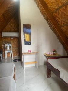 a living room with a bed and a table at Sea Breeze Camp in Siquijor