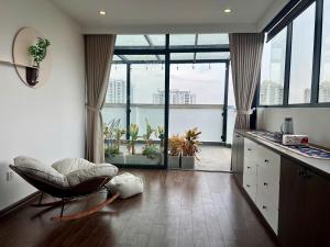 a living room with a chair and a large window at Sky villas with large balcony in Hanoi