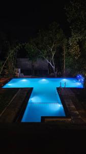 a swimming pool at night with blue lights at Royal Heaven Wayanad in Ambalavayal +9 photos