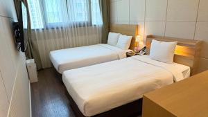 a hotel room with two beds and a table at Hotel Icc in Daejeon +34 photos