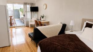 a bedroom with a bed and a living room at Verandah Suite in Seacliff