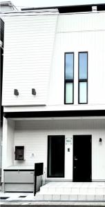 a white house with a bench in front of it at 蝉時雨－大正 in Osaka