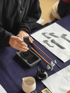 a person sitting at a table holding a cell phone at B&B Hachi in Kyoto