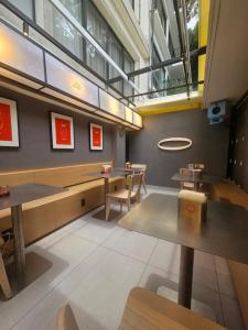 a restaurant with tables and benches and a window at District Polanco by Lumina in Mexico City