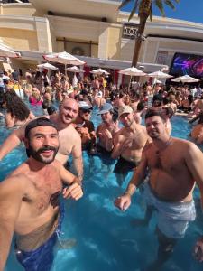 a group of men sitting in a swimming pool at Sin City Hostel in Las Vegas