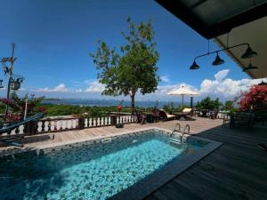a swimming pool with a table and an umbrella at Baan Sahai Tone บ้านสหายโทน in Ko Larn